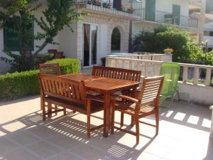 a wooden table and two chairs sitting around a wooden table at Apartments Villa Luce in Makarska