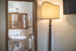 a bathroom with a sink and a mirror and a lamp at Agriturismo Tenuta Armaiolo in Rapolano Terme