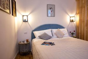 a bedroom with a white bed with a blue headboard at Amazing Trevi Fountain in Rome