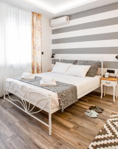a bedroom with a bed with a striped wall at Casablanca apartment in Belgrade