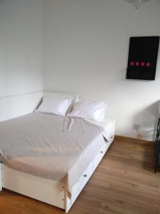 Bett in einem Zimmer mit einer weißen Wand in der Unterkunft Casa da Tia Adozinda in Lissabon