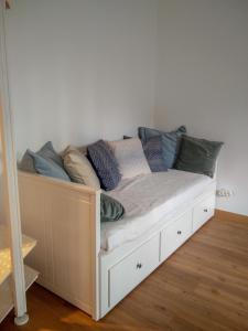 uma cama com almofadas num quarto em Casa da Tia Adozinda em Lisboa