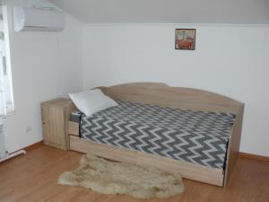 a bed with a wooden frame in a room at Hostynnyi Botsiun in Dubno