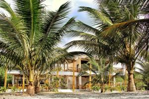 duas palmeiras em frente a um edifício em Seaside Garden Ecolodge Mompiche em Mompiche