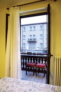1 dormitorio con ventana y vistas a un edificio en Hotel Cortina en Mestre