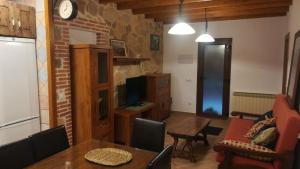 ein Wohnzimmer mit einem Esstisch und einem TV in der Unterkunft Refugio La Covatilla I,II,III y IV in La Hoya