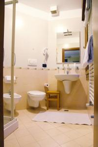 a bathroom with a sink and a toilet and a mirror at Hotel Cortina in Mestre