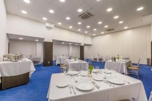 a banquet hall with white tables and chairs at Bristol Guararapes Fortaleza Centro de Eventos in Fortaleza