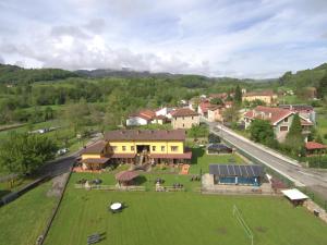 an aerial view of a town with a large green field at Apartamentos El Castañeu in Corao