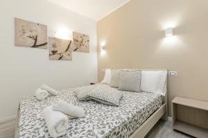 a white bedroom with a bed with towels on it at Holiday Home Taormina 2 in Taormina
