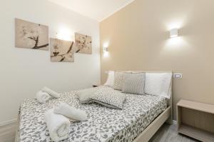タオルミーナにあるHoliday Home Taormina 2の白いベッドルーム(タオル付きのベッド付)