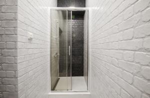 een glazen douche in een witte bakstenen muur bij MyAparts R1 in Lviv