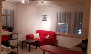 uma sala de estar com um sofá vermelho e uma janela em Apartment Littau em Lucerna