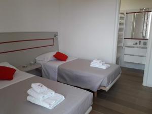 ein Hotelzimmer mit 2 Betten und einem Waschbecken in der Unterkunft Jolie Julie Accomodation in Sassari