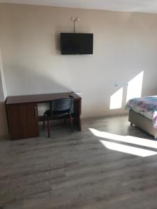 um quarto com uma secretária, uma cama e uma televisão em Gunes Hotel em Hacıbektaş