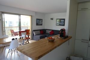 eine Küche und ein Wohnzimmer mit einem Tisch und einem Sofa in der Unterkunft Eden Beach in Cannes
