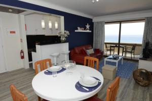 cocina y sala de estar con mesa blanca y sillas en Edifico Baia Apartment, en Funchal