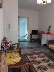 a living room with a table with flowers on it at Marios' Suite in Tinos