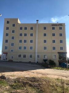 a large tan building with a sign on it at Gunes Hotel in Hacıbektaş