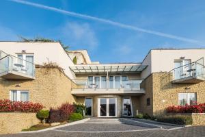 an exterior view of a house with a brick wall at Zenit Wellness Hotel Balaton in Vonyarcvashegy