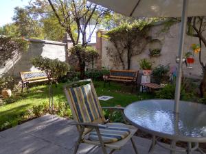 un patio con mesa, sillas y bancos en El Balcon Hostal Turistico, en Arequipa