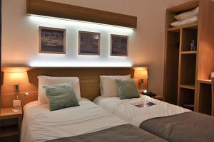 a hotel room with two beds and two lamps at Contact Hotel Utah Beach Carentan in Carentan