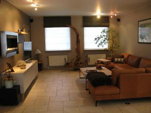 a living room with a couch and a table at BCozy vakantievilla Belgie in Kortrijk