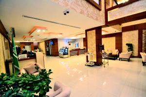 un hall avec des meubles blancs et des plantes dans un bâtiment dans l'établissement Your Home Apartment Hotel, à Dammam