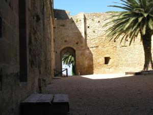 a building with a palm tree next to a wall at SEGESTA Nouveau Bedding in Salemi