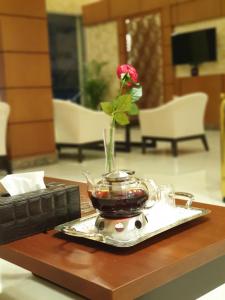 a flower in a vase on a tray on a table at Your Home Apartment Hotel in Dammam