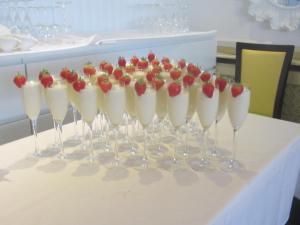 een rij wijnglazen met aardbeien erin op een tafel bij Ababeel Hotel in Birmingham +12 foto's