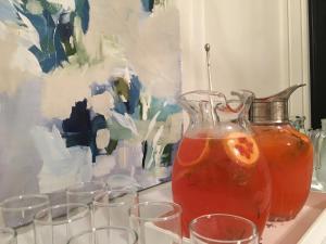 una mesa con vasos y un jarrón con una bebida en Elena en Azul