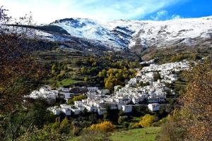 a small town in the middle of a snow covered mountain at Apartamentos Casa FERMINA - A 2 horas de las pistas de esquí in Trevélez