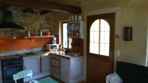 a kitchen with white cabinets and a sink and a window at Le Mazet in Remoulins
