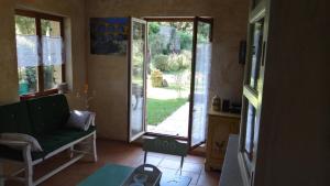 a living room with a green couch and a sliding glass door at Le Mazet in Remoulins