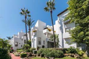 zewnętrzny widok na budynek z palmami w obiekcie Costa Del Sol Beach Apartment w mieście Estepona