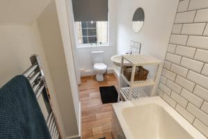a bathroom with a tub and a toilet and a sink at Sapphire Home Stay in Liverpool
