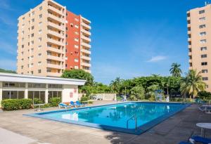 a swimming pool in front of two tall buildings at Ambleside & Turtle beach towers in Ocho Rios