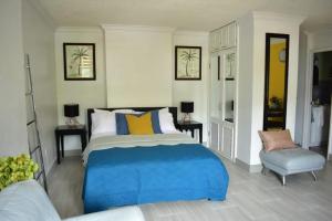 a bedroom with a blue bed and a chair at Ambleside & Turtle beach towers in Ocho Rios