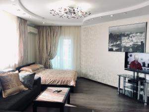 a living room with a bed and a couch at 39/2 улица Дальняя in Krasnodar