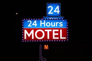 a sign for a hour motel with the number at 24 Hours Motel in Los Angeles