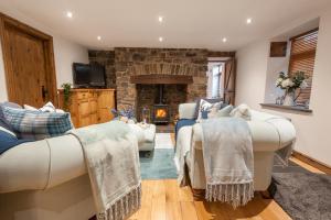 a living room with a couch and a fireplace at Bryn-Y-Groes Cottage in Ystradgynlais