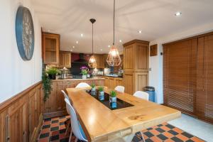 a large kitchen with a wooden table and chairs at Bryn-Y-Groes Cottage in Ystradgynlais