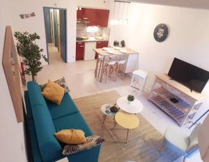 een woonkamer met een blauwe bank en een keuken bij Au coeur de la Grande Motte in La Grande-Motte