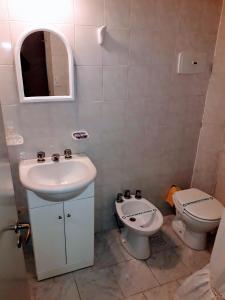 a bathroom with a sink and a toilet at Posada de la Villa in Villa Gesell