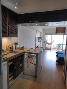 a kitchen and living room with a table and a couch at Beach & Relax - Studio in Costa da Caparica