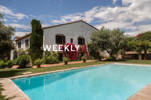 a villa with a swimming pool in front of a house at Masia Sitges Mas Peirot Geniune Farmhouse 20 min walk from beaches 60 Heactares of Wine Fields Garden AC Until 18 people in Cubelles