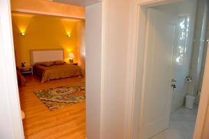 a hallway leading to a bedroom with a bed at Grand White City Hotel in Berat