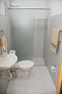 y baño con ducha, aseo y lavamanos. en Pousada e Posto Amigão en São Gonçalo do Amarante