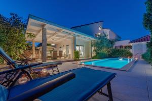 a home with a swimming pool and a house at After All in Mandre